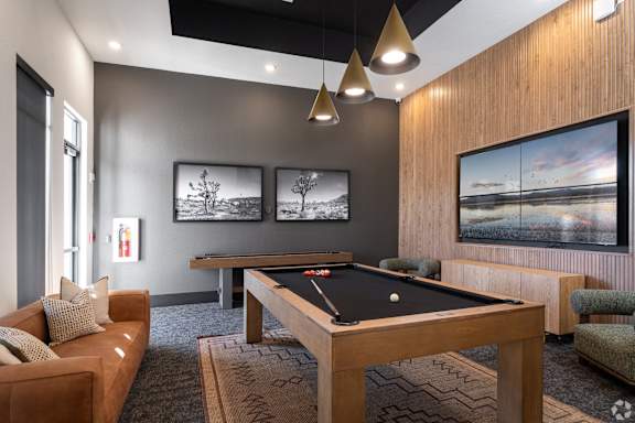 A room with a pool table and a couch.