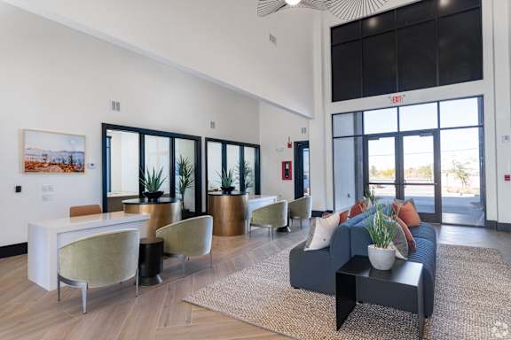 A modern living room with a grey couch and a white table.