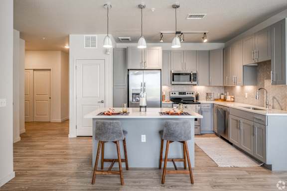 A kitchen with a bar stool at the island.