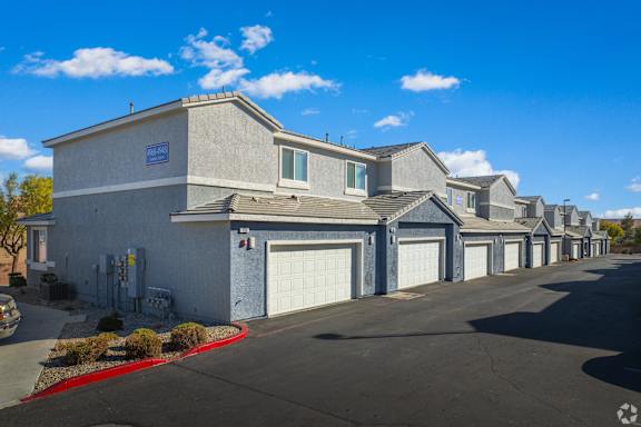 A row of houses with garages and driveways.