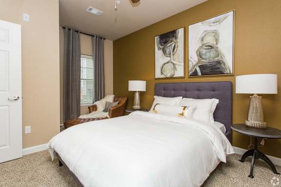 a bedroom with a bed and a window  at The Retreat Apartment Homes, Williston, North Dakota