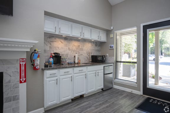 a kitchen with white cabinets and a sink and a window