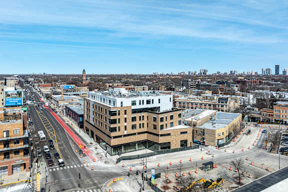 A city street with a red lane and a construction site.