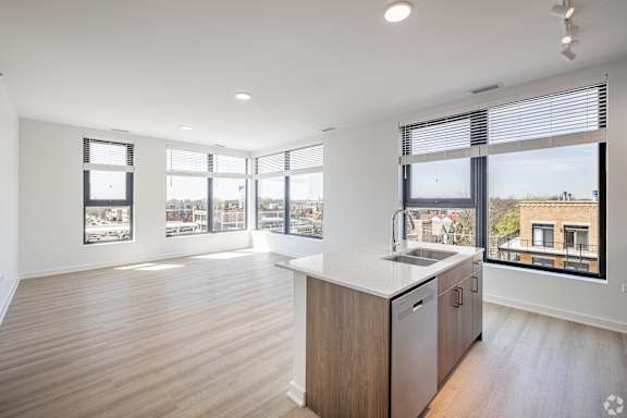 A kitchen with a wooden floor and a large window overlooking a cityscape.