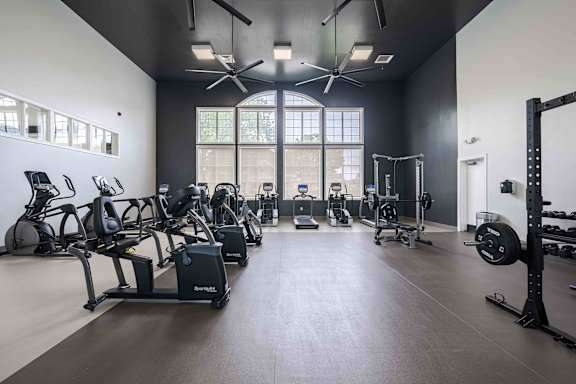 A gym with a variety of equipment including treadmills, stationary bikes, and weightlifting machines.