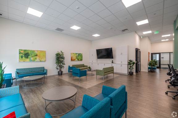 A modern office space with blue and green seating.