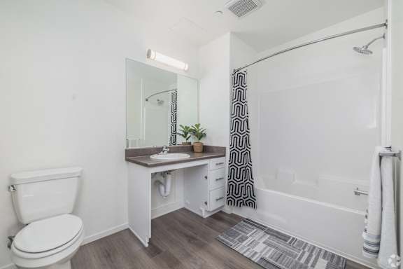 A white toilet sits next to a sink in a small bathroom.