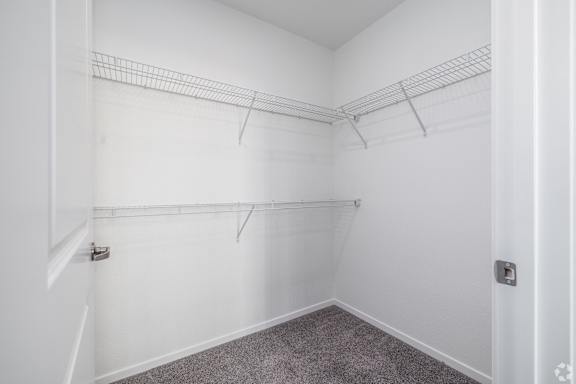 Empty room with white walls and grey carpet.