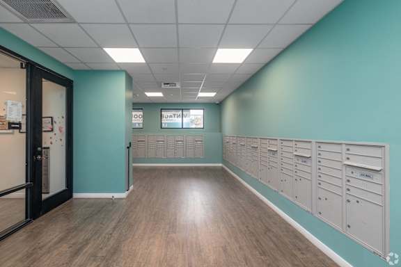 A long hallway with a row of mailboxes on the wall.