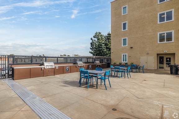 A large outdoor patio area with blue chairs and tables.