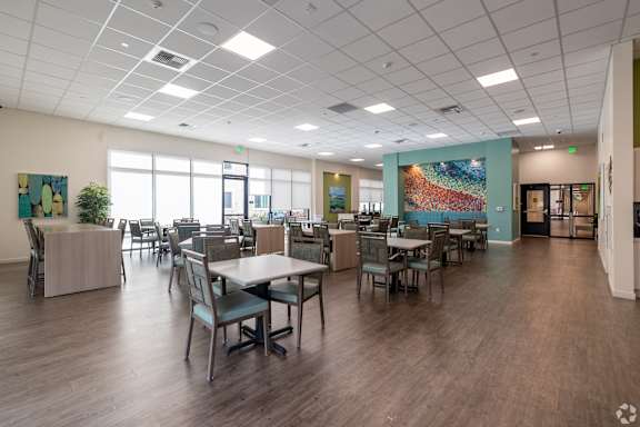 A large clubhouse with tables and chairs and a plant.