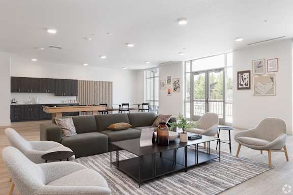 A modern living room with a grey sofa, a black coffee table, and a grey armchair.
