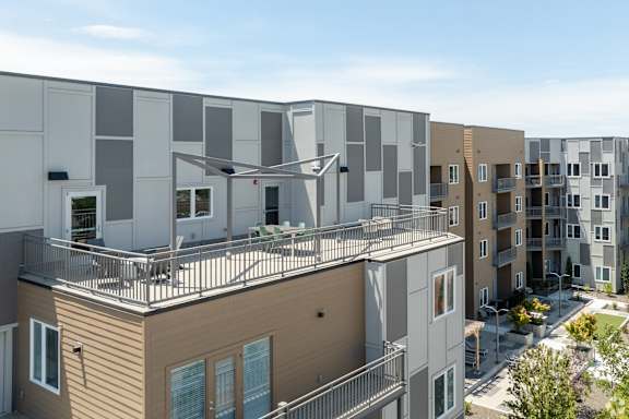 A modern apartment complex with balconies and a mix of beige and white exterior colors.
