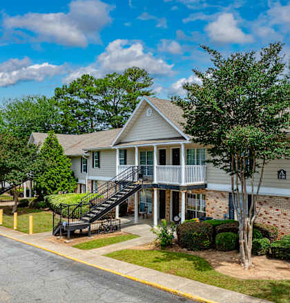 A residential building with a tree in front.