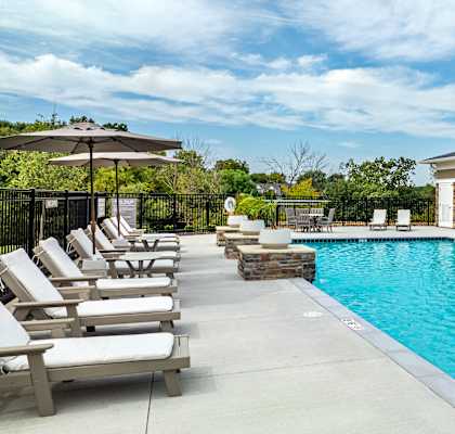 A pool with a gazebo and sun loungers.