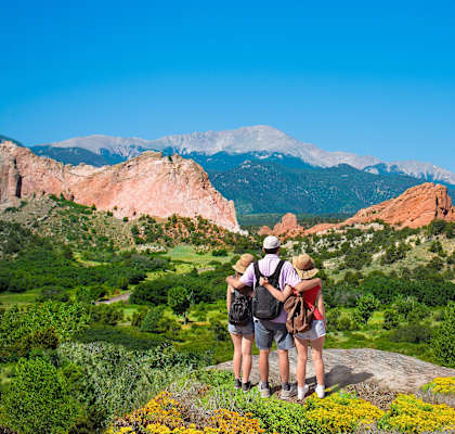 a group of people standing on a rock overlooking the mountains