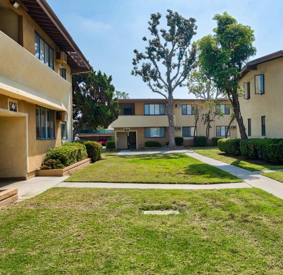 view of grassy area between buildings at Serrano Apartments, West Covina, California