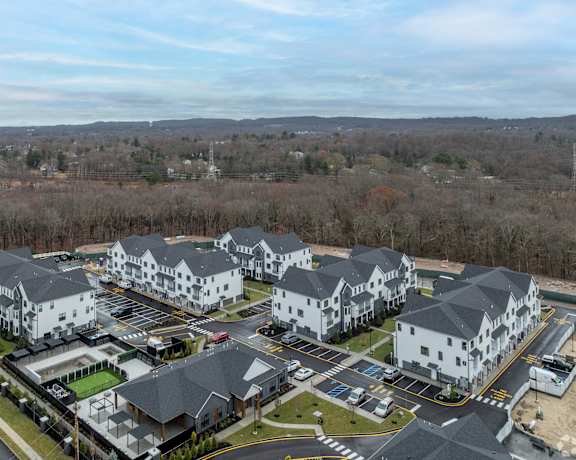 A large white building complex with a parking lot in front.