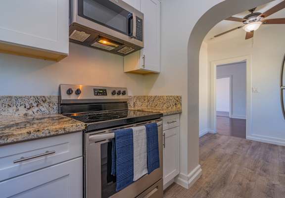 A kitchen with a stove top oven and microwave above it.