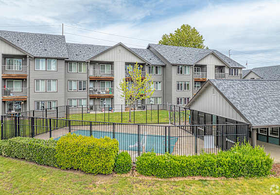 A large apartment complex with a pool in the foreground.