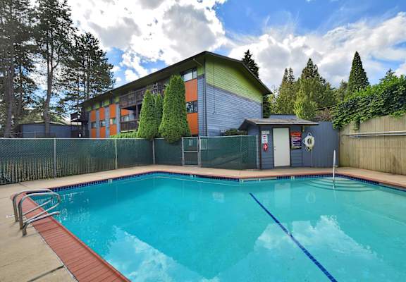A swimming pool in front of a house.