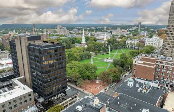 A cityscape with a large building in the foreground and a church in the distance.