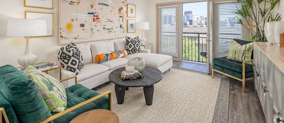 a living room with a ceiling fan and a door to a balcony