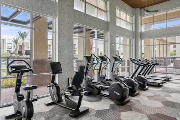 A gym with treadmills, elliptical machines, and stationary bikes.