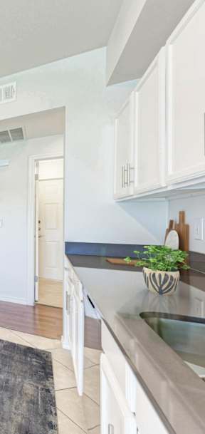 A kitchen with white cabinets and appliances.