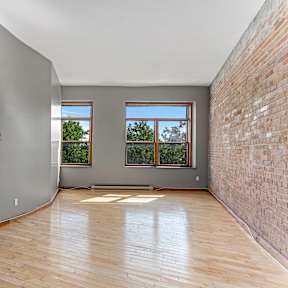 A room with wooden floors and a brick wall.