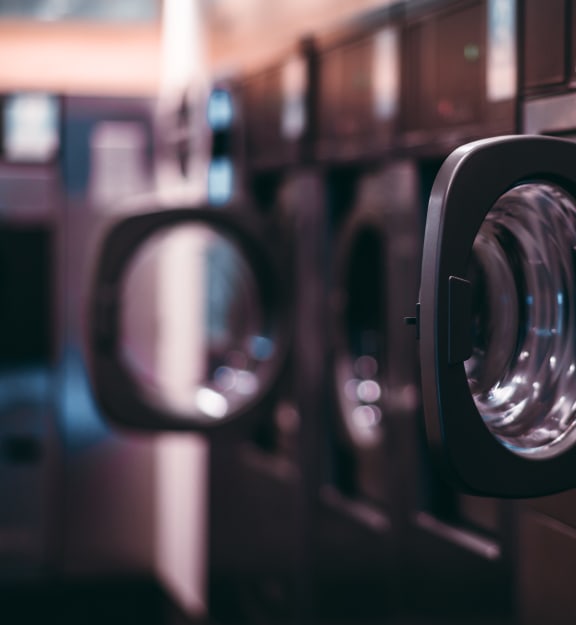 a row of industrial washing machines in a laundromat