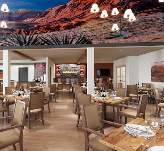 A restaurant with tables and chairs and a desert scene on the wall.