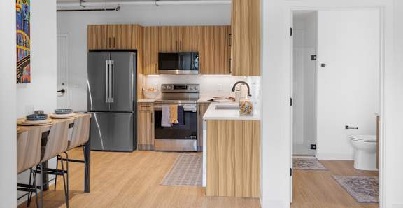 A kitchen with a refrigerator, sink, and oven.