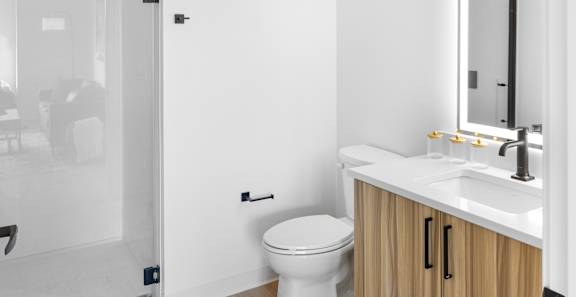 A white toilet sits next to a sink in a modern bathroom.