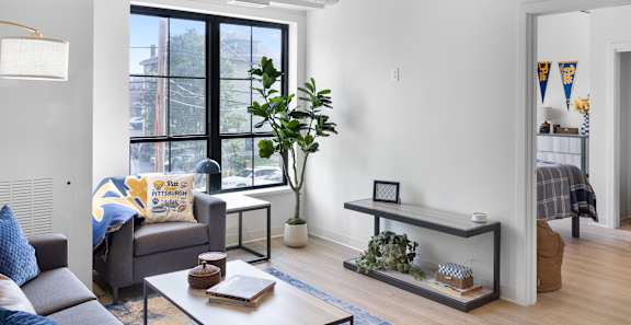 A living room with a grey couch and a white coffee table.
