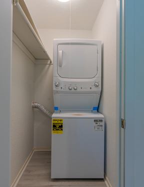 A white washing machine in a narrow hallway.