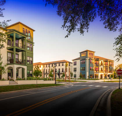 A street with a stop sign and apartment buildings on the side.
