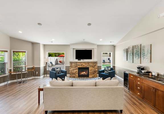 a living room with a couch and chairs and a fireplace at Sage Apartments, Washington