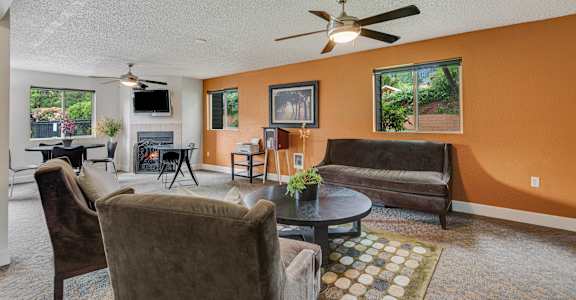 a living room with couches and a table and a ceiling fan at Eagles Landing Apartments, Everett, 98204