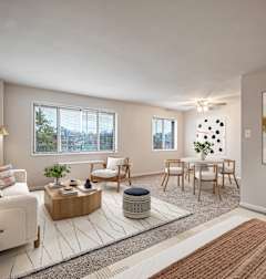 a living room with two couches and a rug and a dining room table