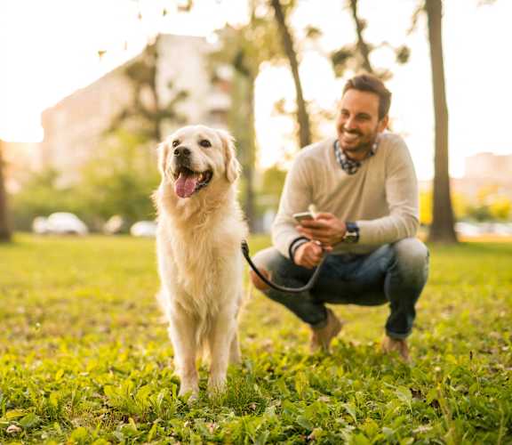 a man with his dog in a park