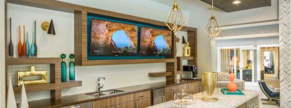 A modern kitchen with a large island and stools.