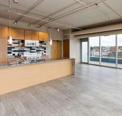 A modern kitchen with a long counter and a view of the city.