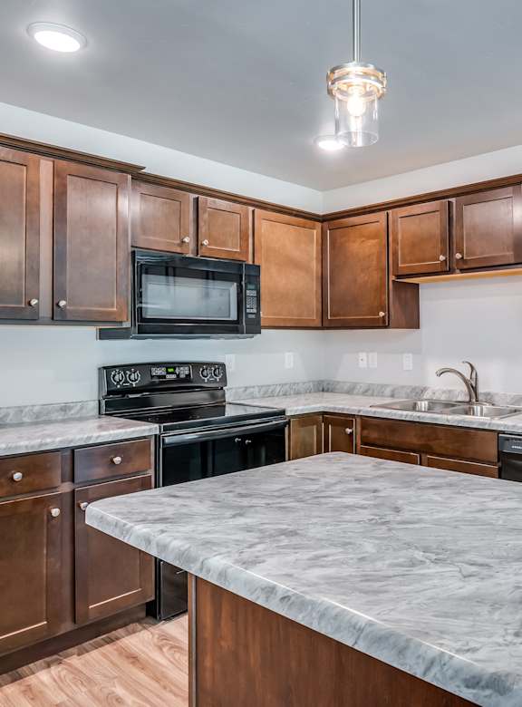 a kitchen with marble counter tops and wooden cabinets