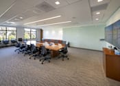 Thumbnail 5 of 13 - A conference room with a long table and chairs.