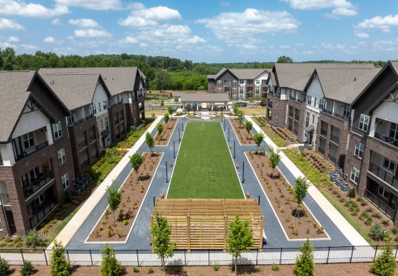 an aerial view of a community garden in front of apartment buildings