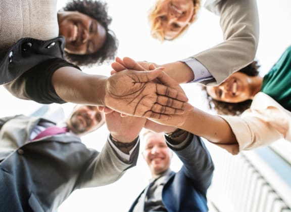 a group of people putting their hands on top of each other
