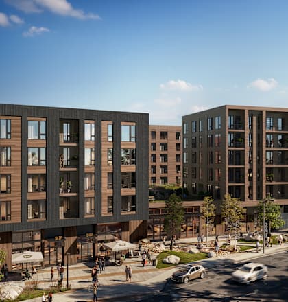 A modern apartment complex with cars parked in front.