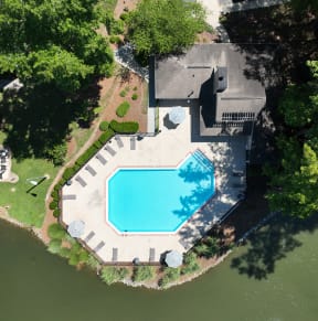 an aerial view of a swimming pool in the backyard of a house
