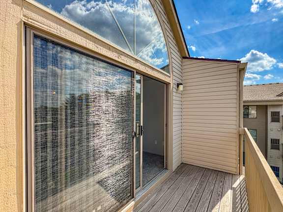 A sunny day with a clear blue sky is reflected in the glass door of a house.